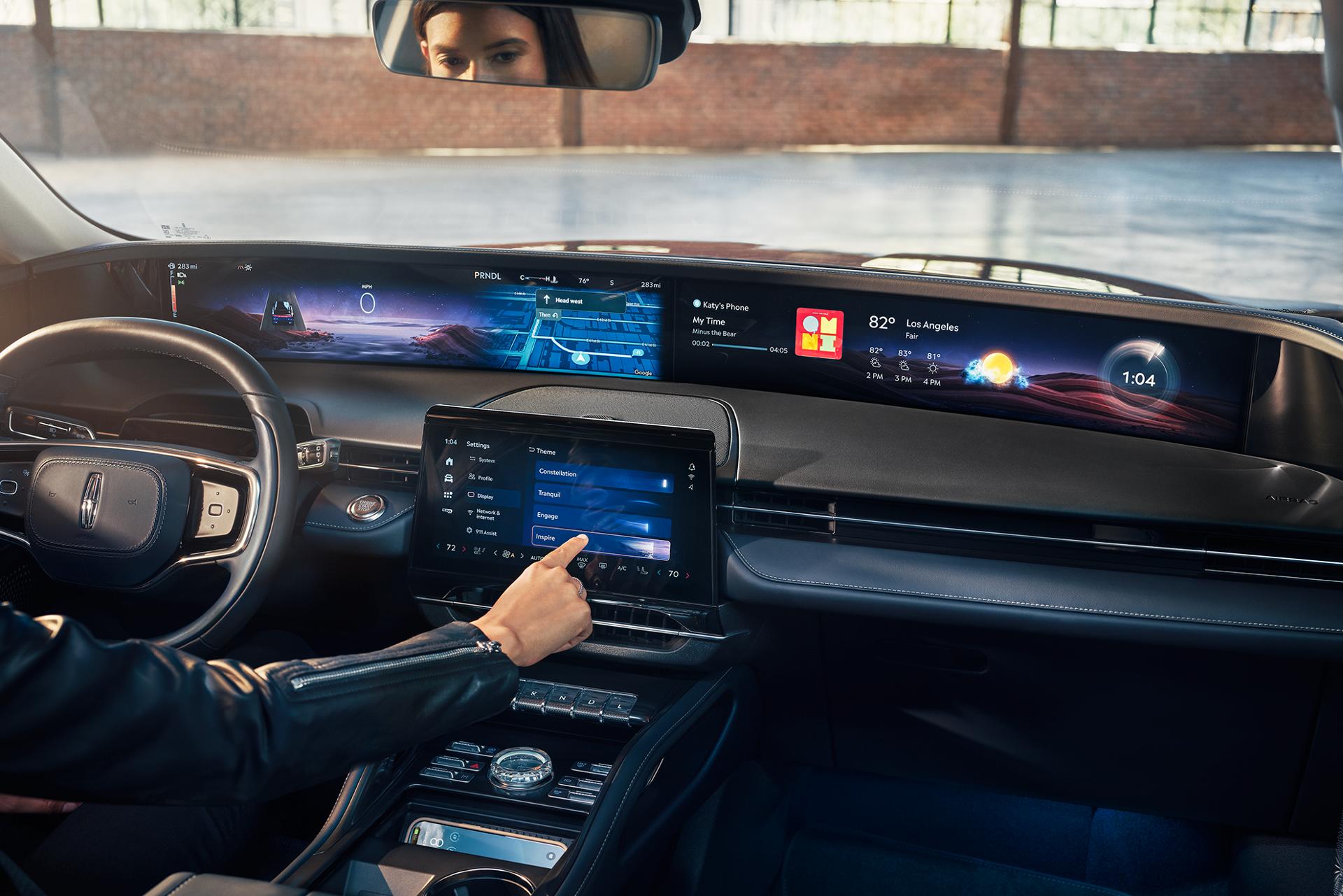 A woman interacting with the center touch-screen inside the 2025 Lincoln Nautilus.